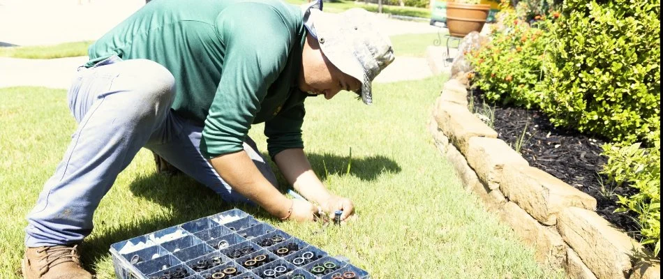 Crew adjusting a sprinkler head nozzle on a lawn in Plano, TX.